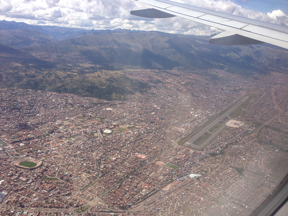 A runway in the middle of the moungtains in the middle of the city.